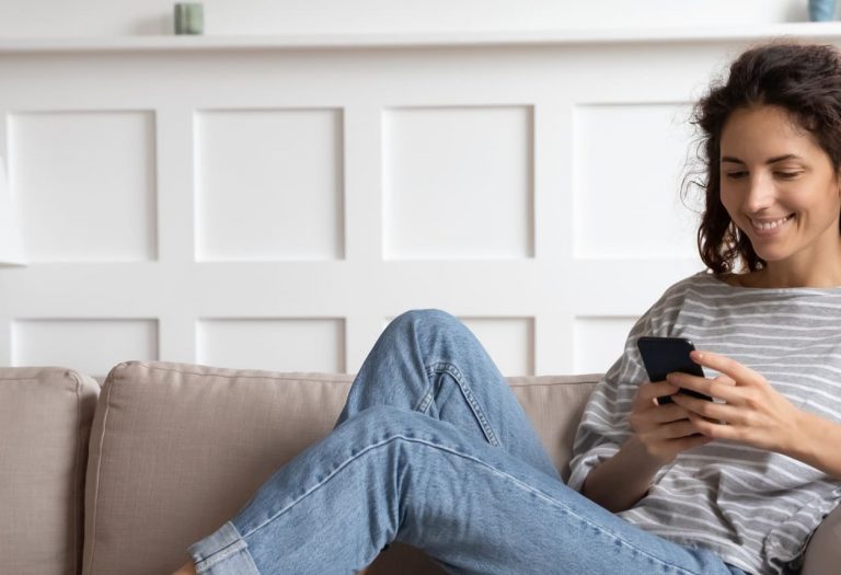 smiling woman registering interest for egg donation on phone