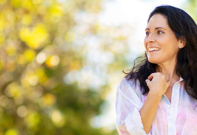 smiling happy woman in shirt with trees in background
